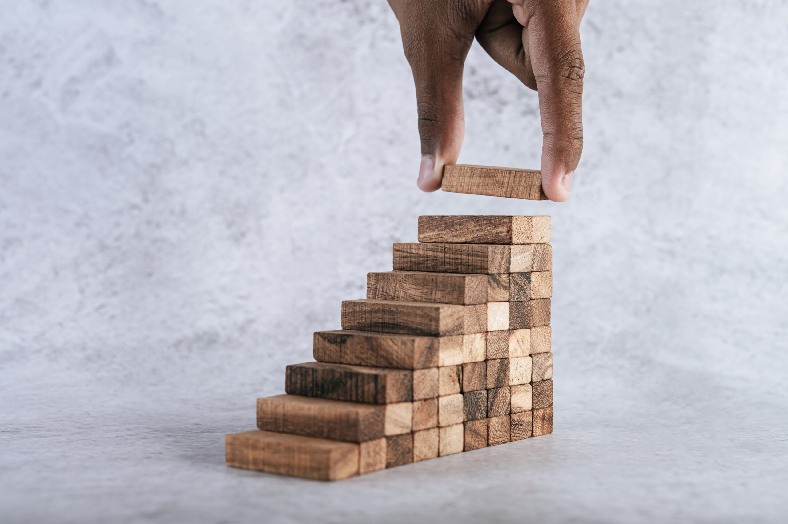 Stacking wooden blocks is at risk in creating business growth ideas.